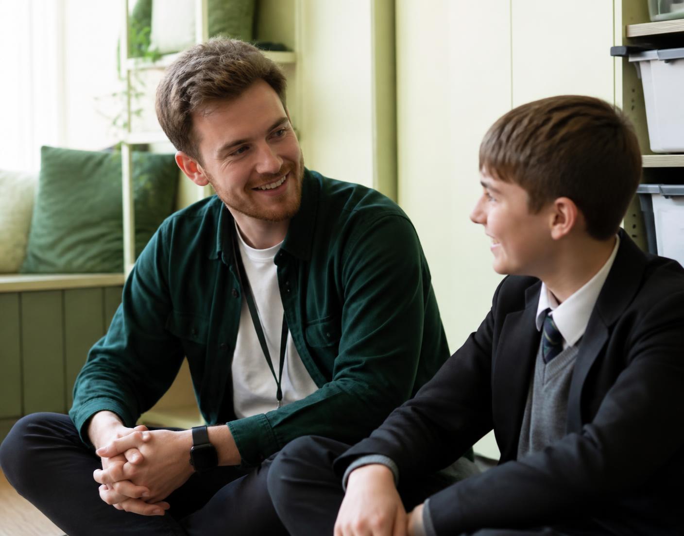 A mentor and student talking in a school setting